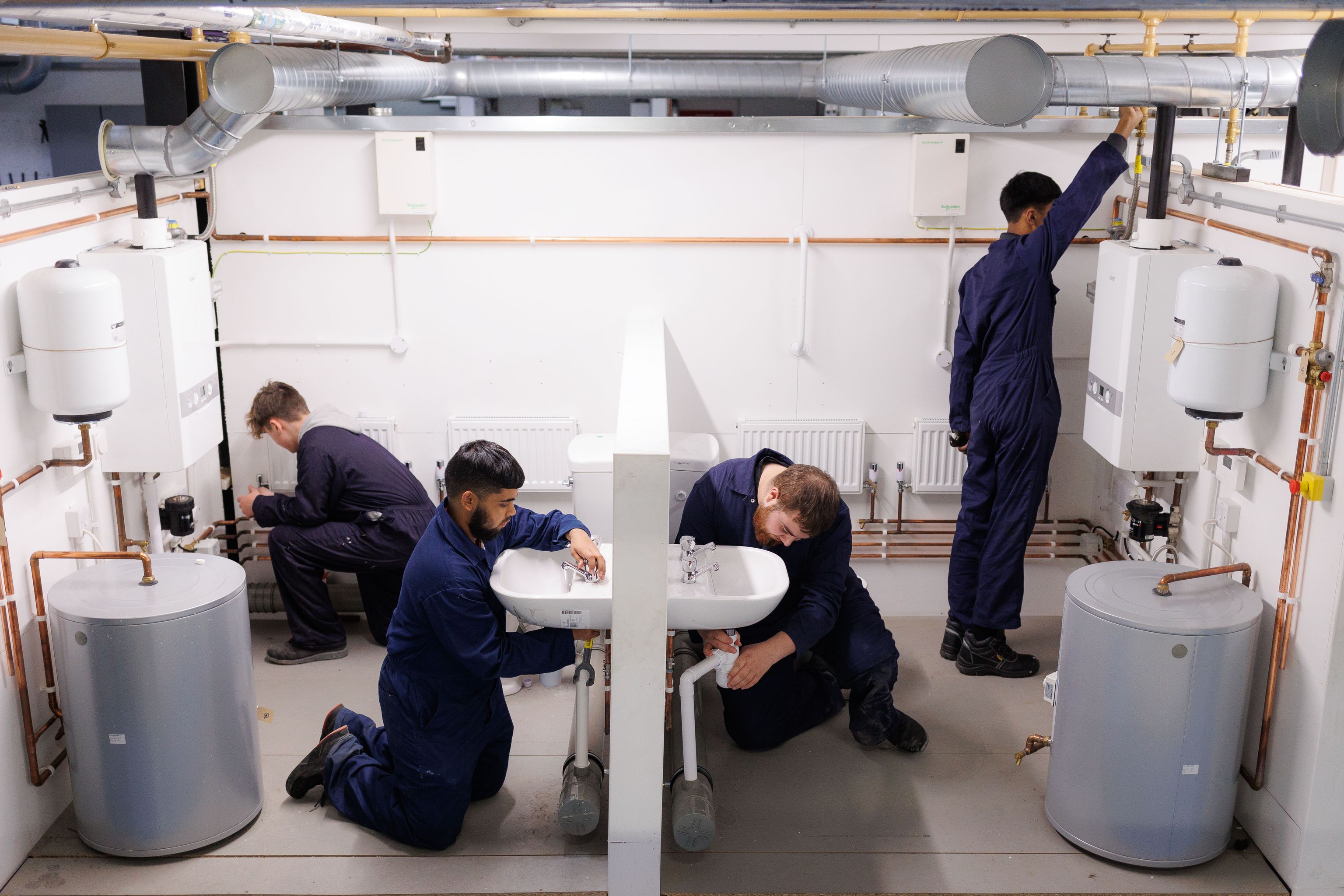 4 young people working in the plumbing classroom