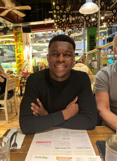 Leicester College student, Leon Tulloch smiling whilst sitting in a restaurant