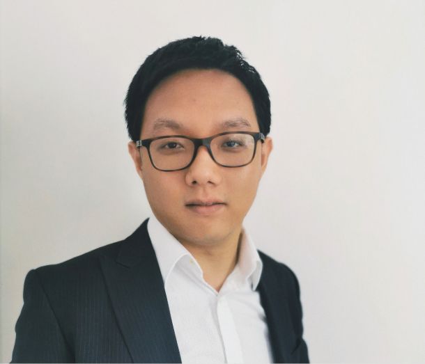 Leicester College Adult Learner, Lei, wearing a suit and glasses