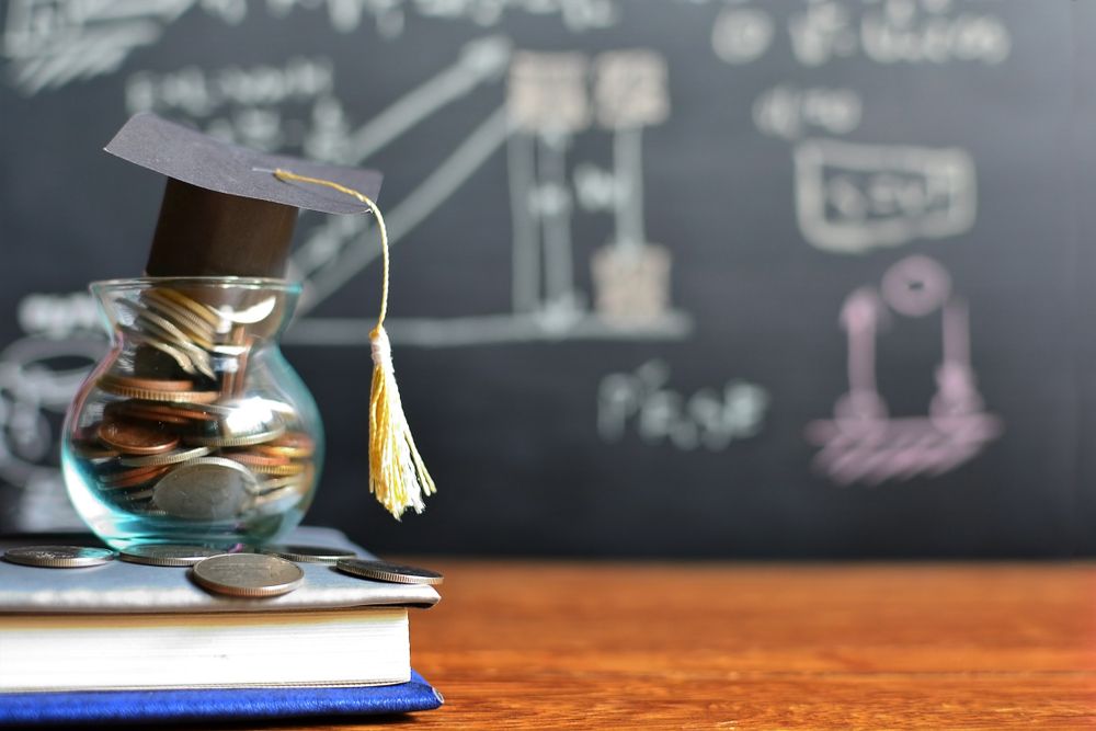 hat-graduation-model-on-coins-saving-for-concept-investment-education-and-scholarships---10039286131