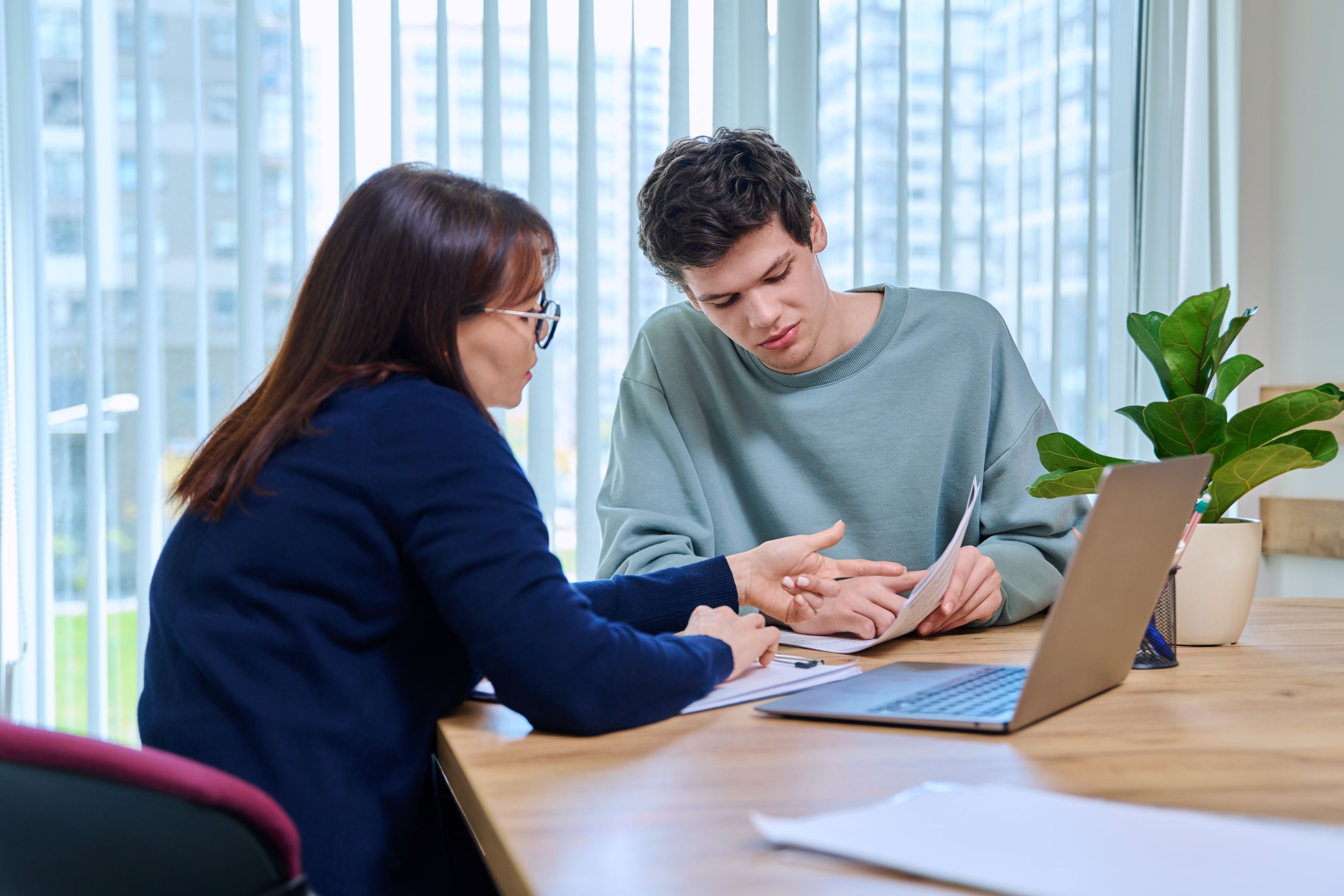 white woman explaining document to young white man