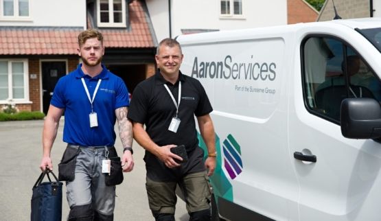 Two white males walking next to an Aaron service van