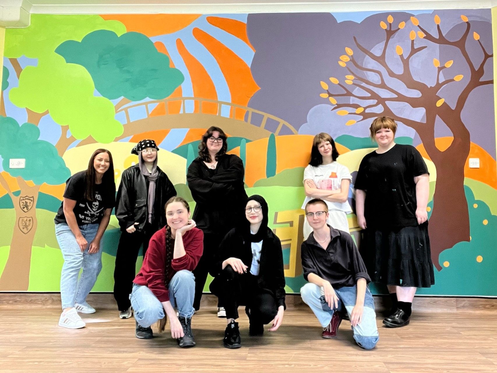 Leicester College Art and Design BTEC students standing in front of the mural they painted at the Hawthorn Centre