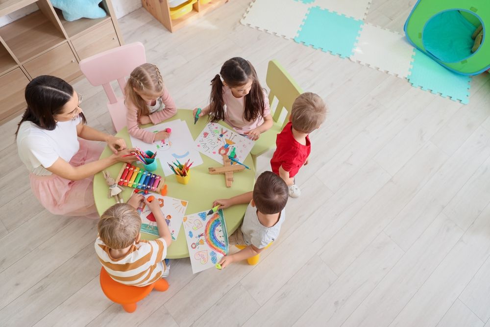 2024-children-around-a-table-nursery-stock-image