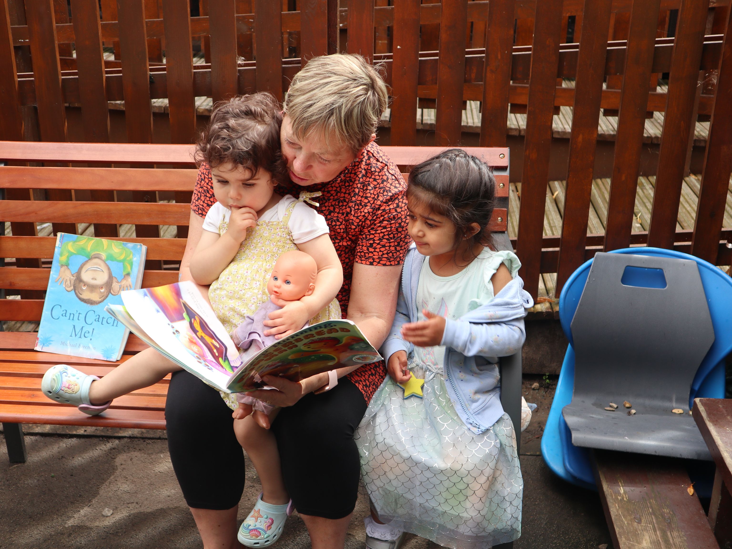 teacher reading a book to children