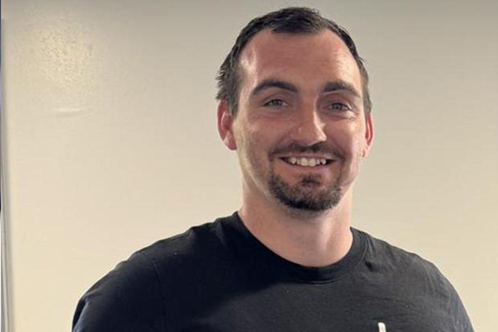 white male in black tshirt looking at camera