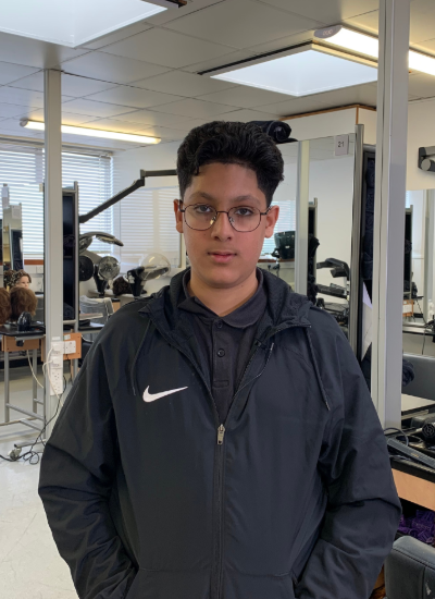 Leicester College Barbering student Luuqman Sattar standing in the training salon on campus